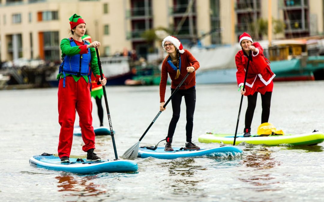 paddleboarders dressed as santa on bristol harbour