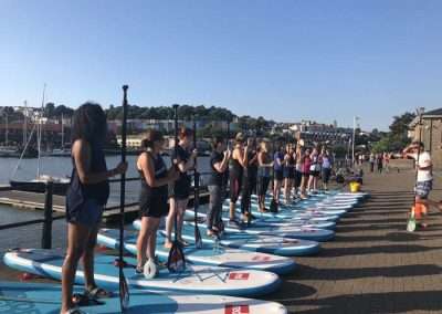 Hen group learning paddleboarding during a paddleboarding hen do in Bristol