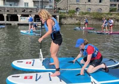 Women paddleboarding together during a paddleboarding hen do in Bristol Harbour