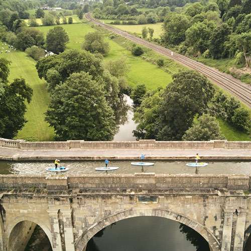 Group paddleboarding over Dundas Aqueduct. Shot from the air by drone