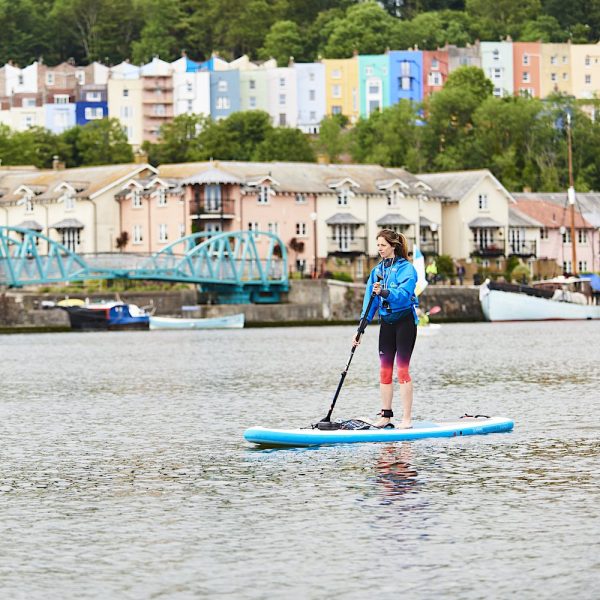 Solo female paddleboarder in Bristol Floating Harbour with iconic Hotwells coloured houses in the background